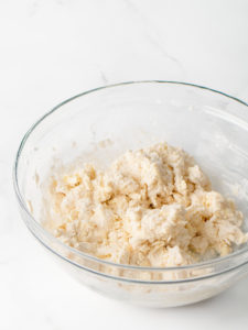 Butter biscuit dough in a large glass mixing bowl.