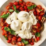 Fresh tomato, basil, burrata and herbs in a large serving bowl.