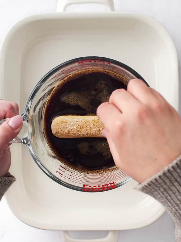 Dipping lady fingers in coffee and rum mixture.