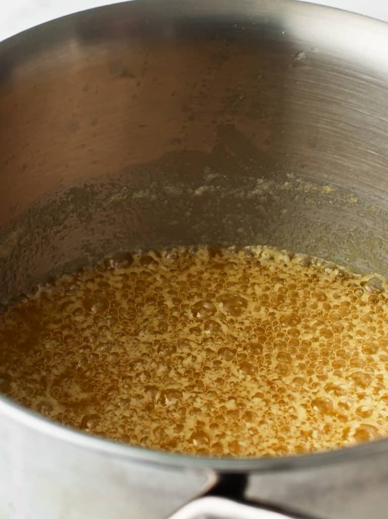 Melted butter in a stainless steel pot.