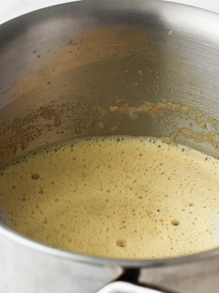 Melted butter in a stainless steel pot.