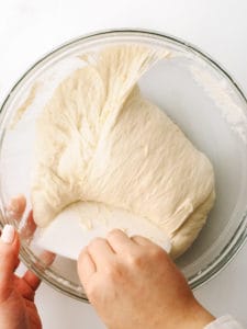 Folding dough into a rough round shape.