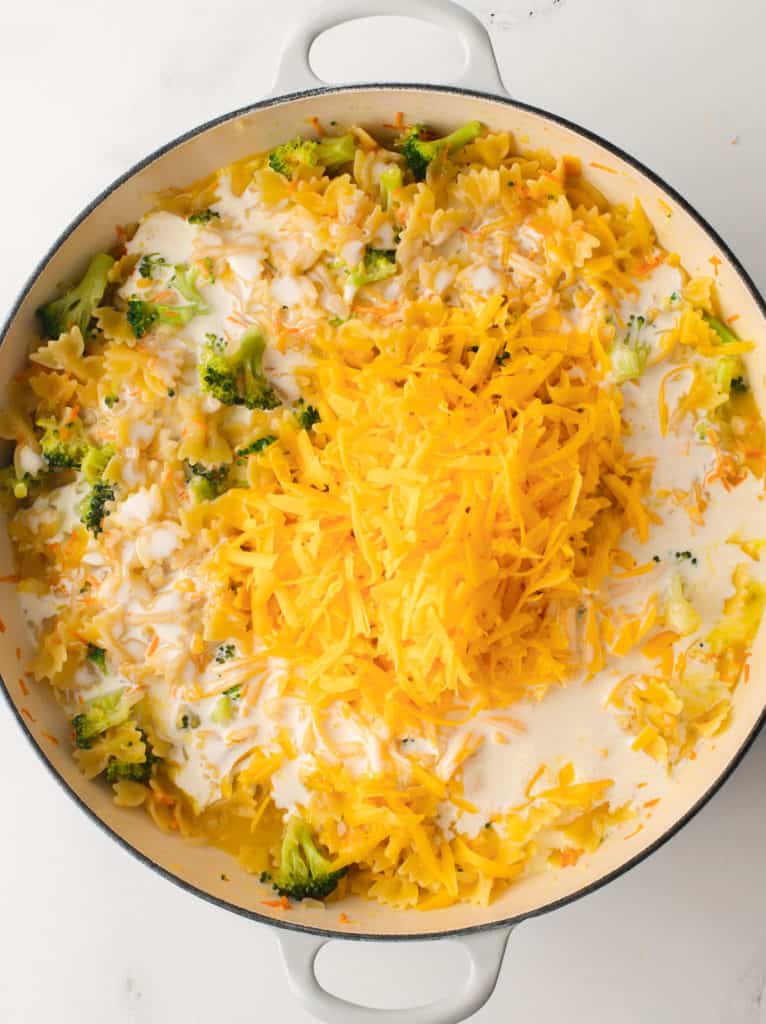 Adding cheese and heavy cream to cooked mirepoix.