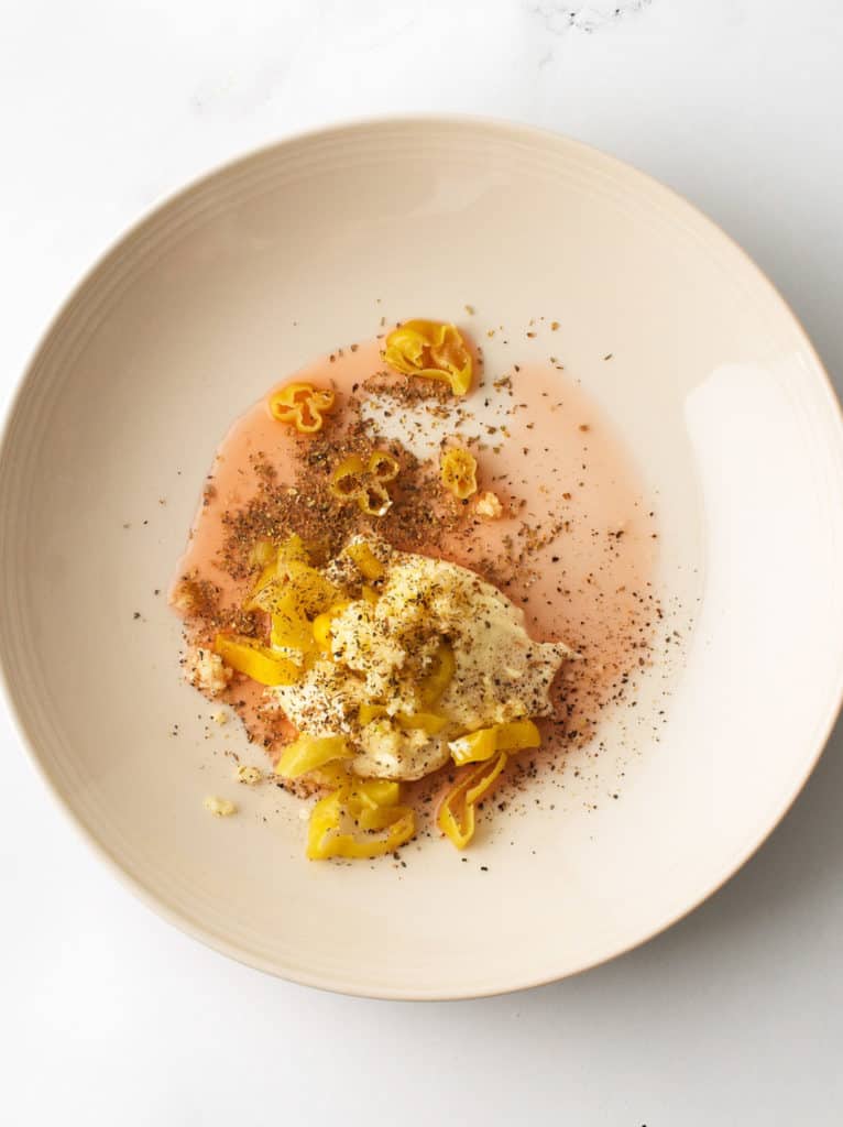 Mixing bowl with mayo, banana pepper, red wine vinegar and spices.