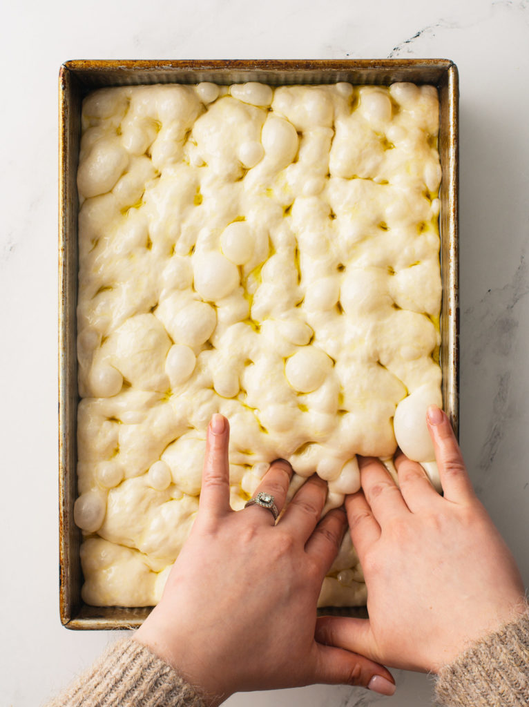 Dimpling the dough.