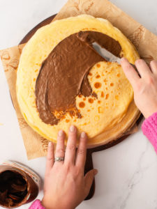 Spreading Nutella inside a crepe.