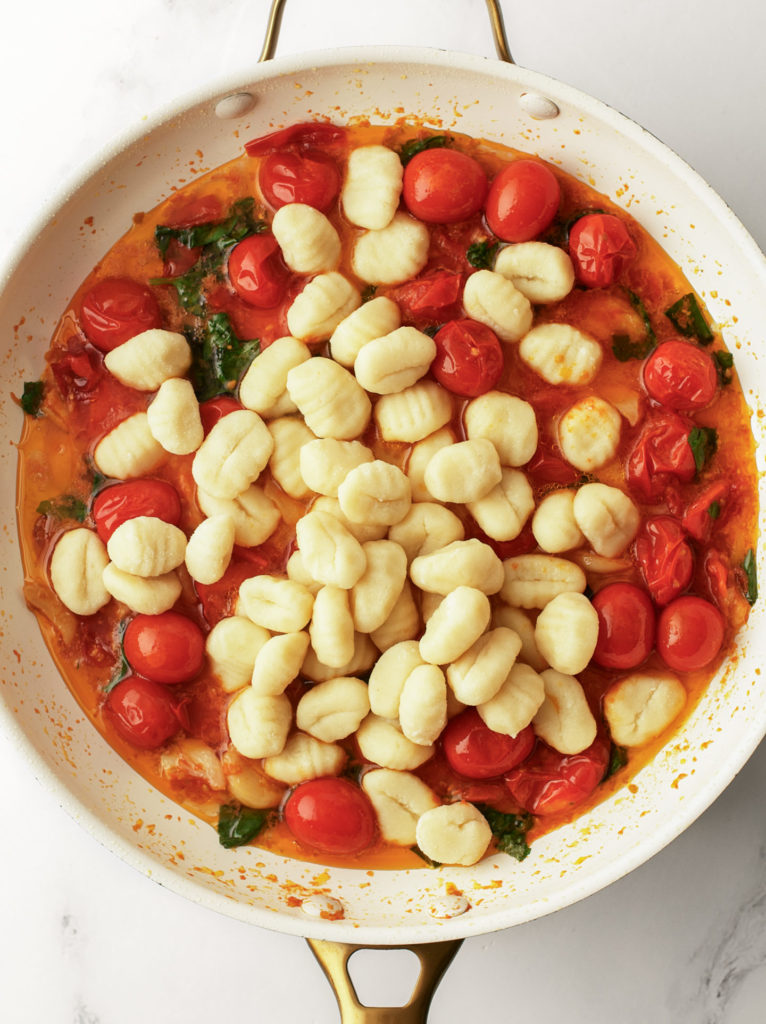 Gnocchi and water added to tomato sauce.