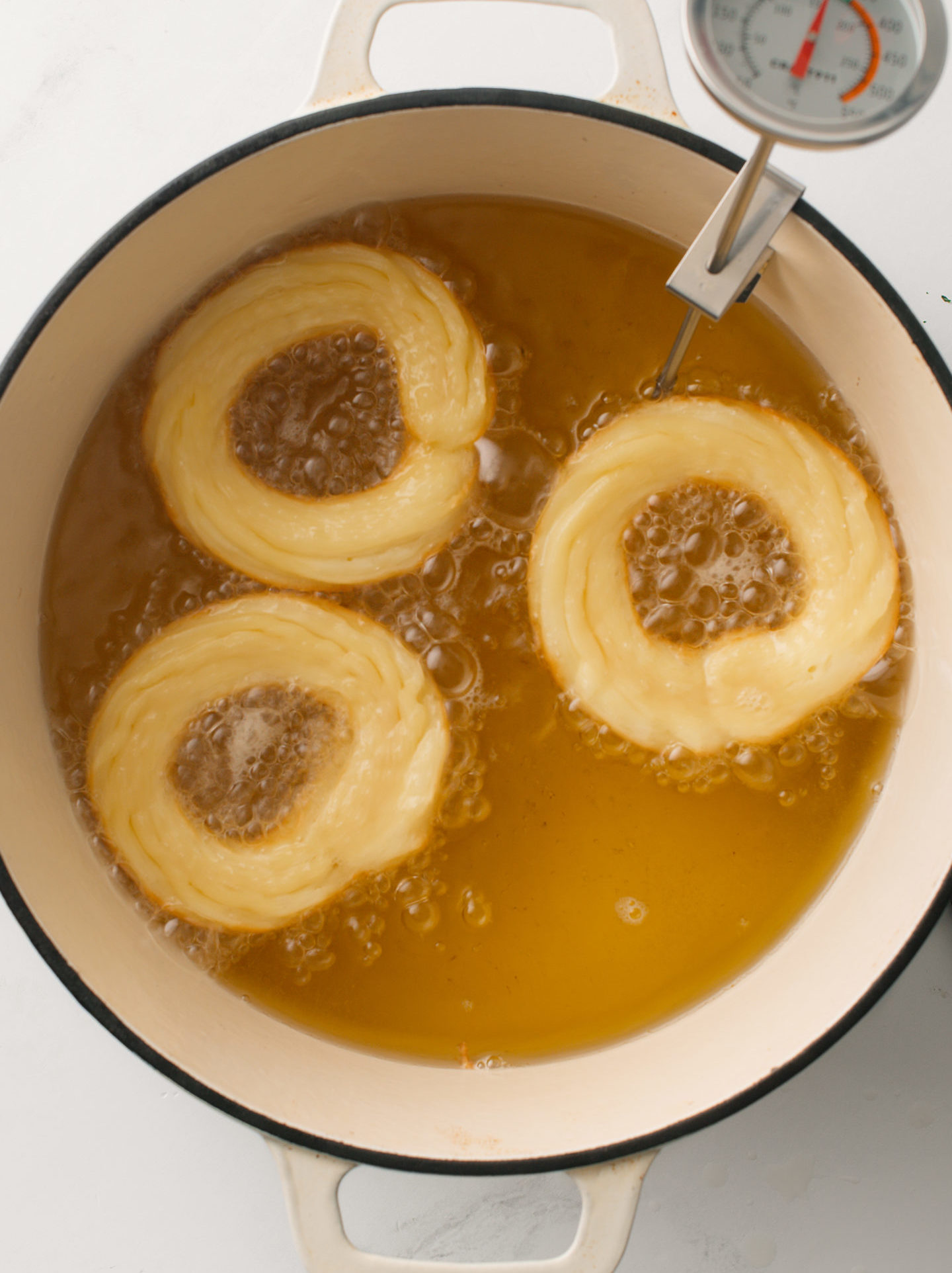 Donuts in frying pan with oil.