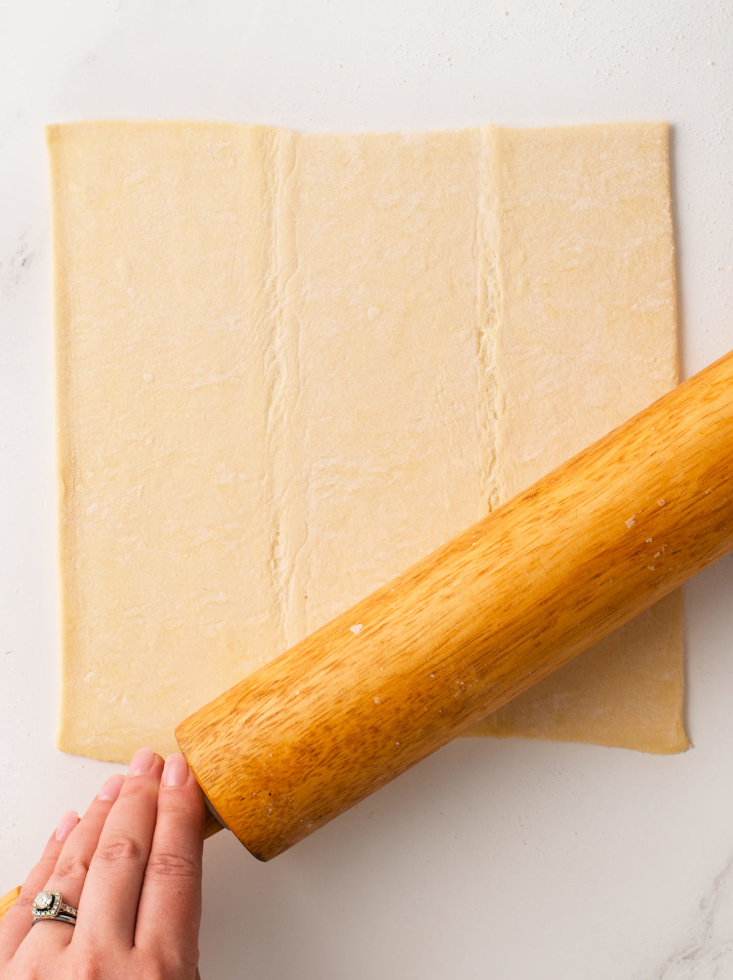 Rolling pin over the puff pastry sheet.