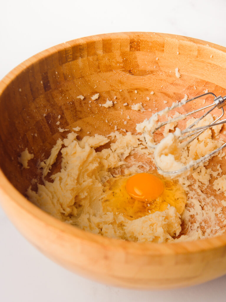 Apple cake batter in large wooden bowl.