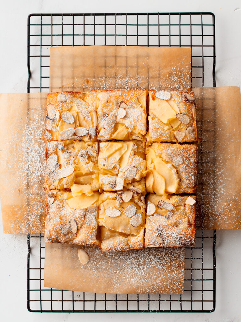 Apple cake sliced on a wire rack.