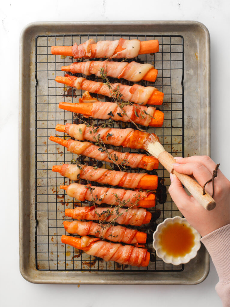 Brushing the bacon wrapped carrots with hot honey.