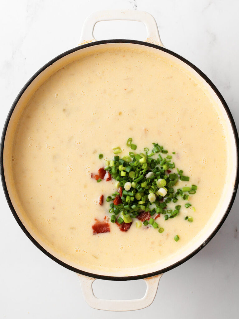 Green onions and bacon toppings in creamy potato soup.