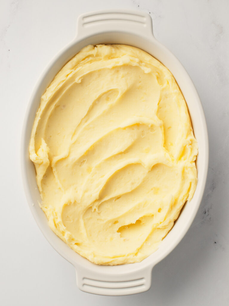 Creamy mashed potato spread in baking tray.