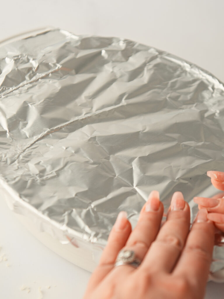 Covering baking tray with foil.