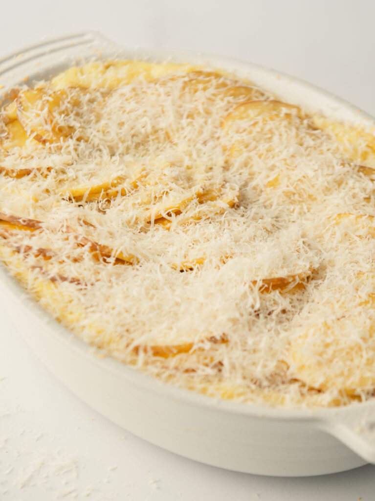 Layer of grated cheese on potato slices.