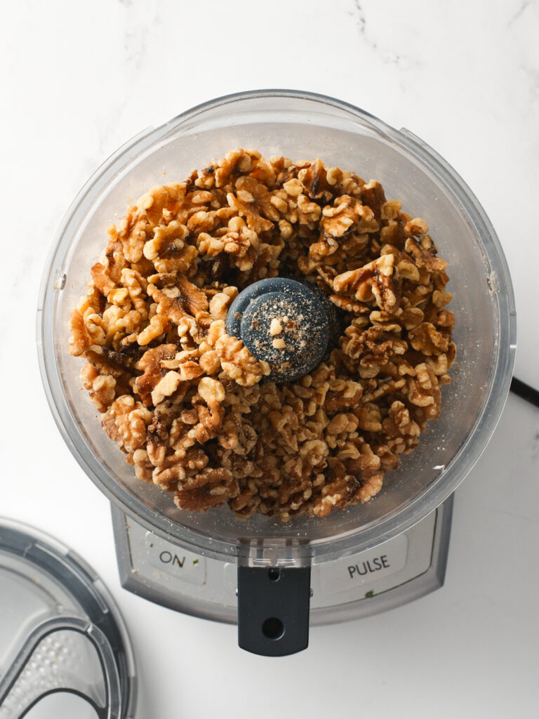 Roasted walnuts inside food processor.