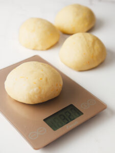 Weighing the brioche dough on kitchen scale.