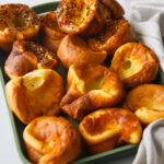 Green pan arranged with popovers and towel.