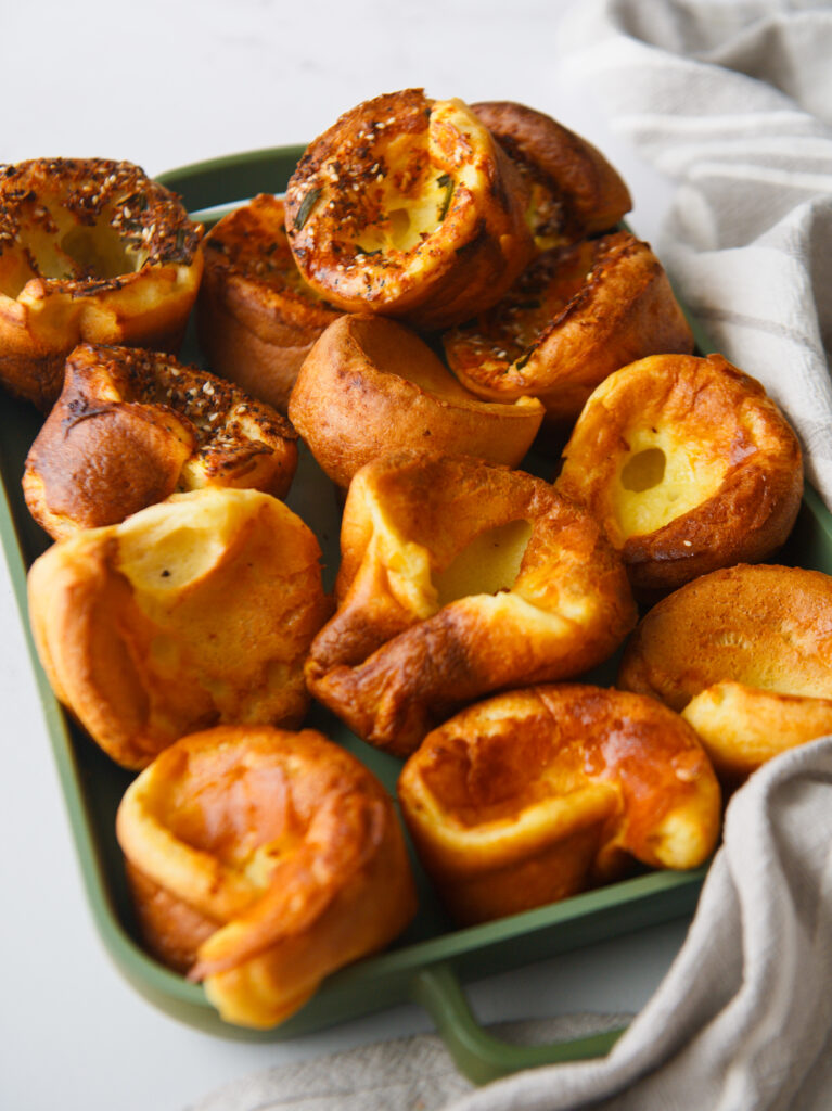 Green pan arranged with popovers and towel.