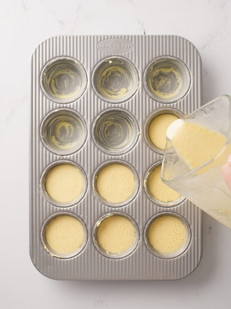 Pouring popover batter into buttered muffin pan.