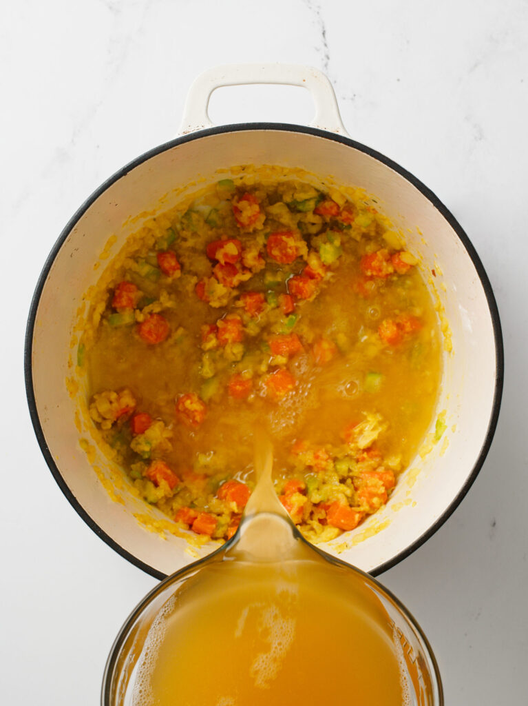 Pouring chicken broth to pot.