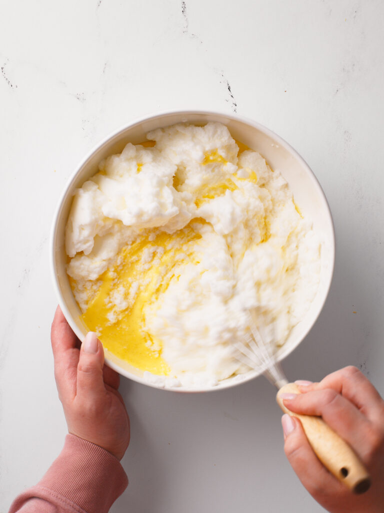 Whisking whipped egg whites with the custard.