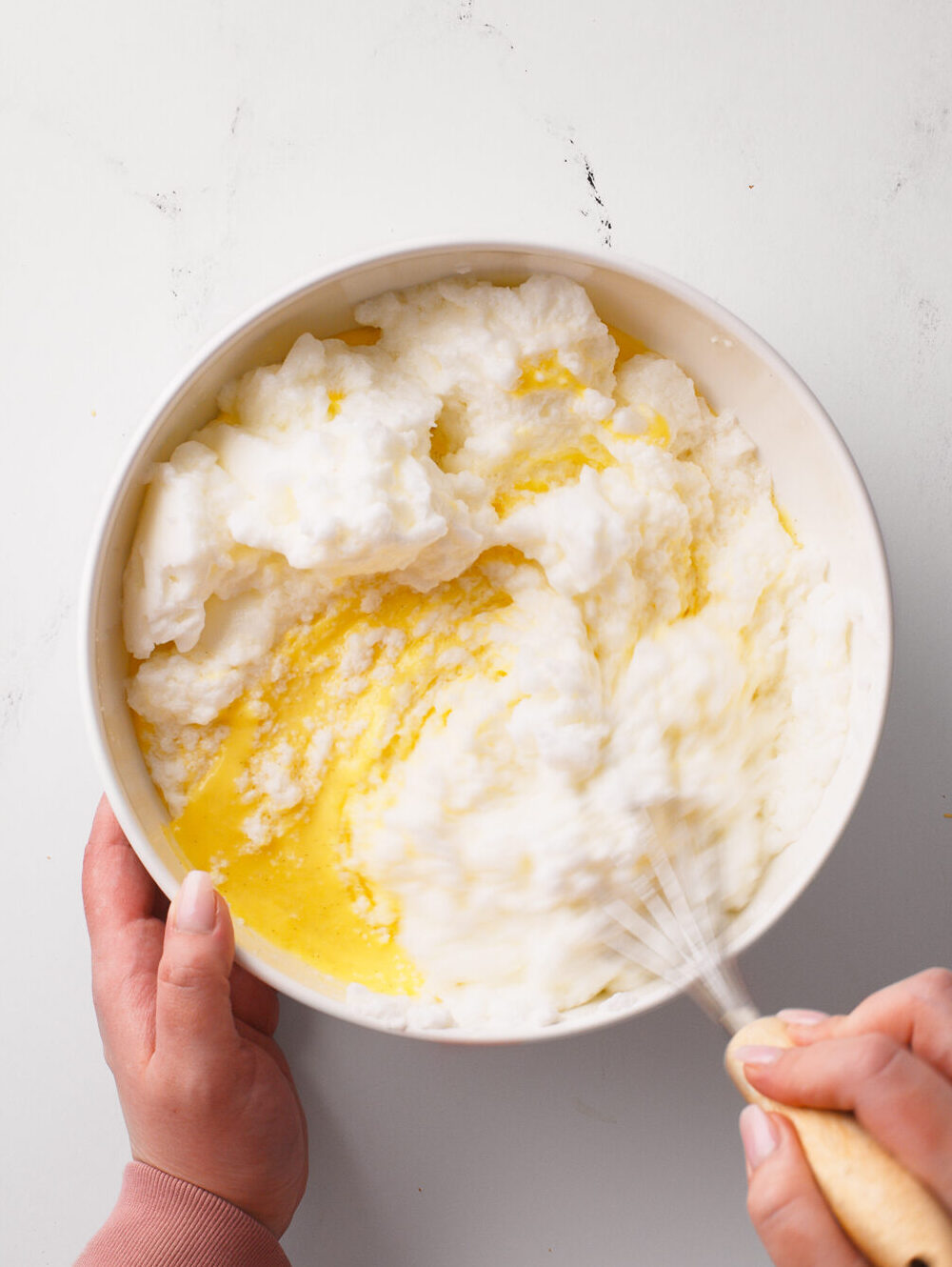 Whisking whipped egg whites with the custard.