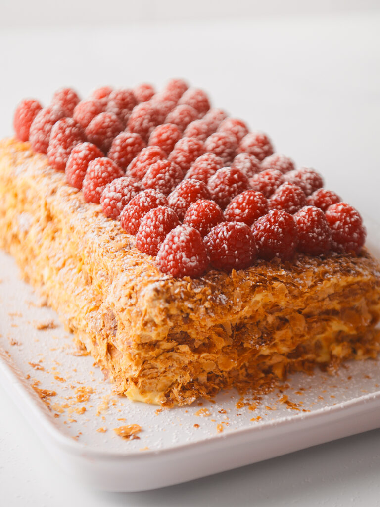 Napoleon Cake topped with a layer of fresh raspberries.