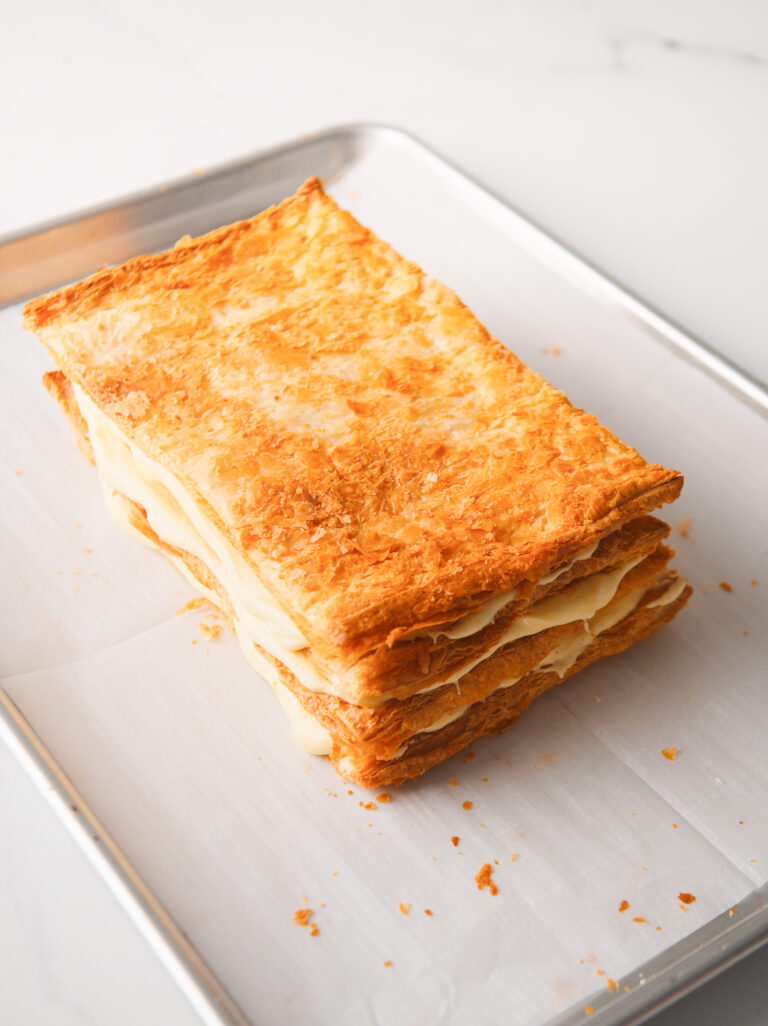 Assembling puff pastry and cream layers.