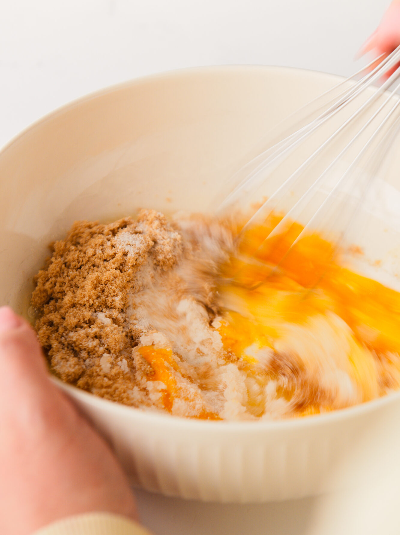 Whisking eggs and sugar in large bowl.