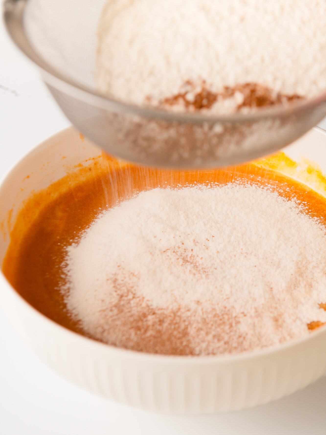 Sifting flour in mixing bowl.
