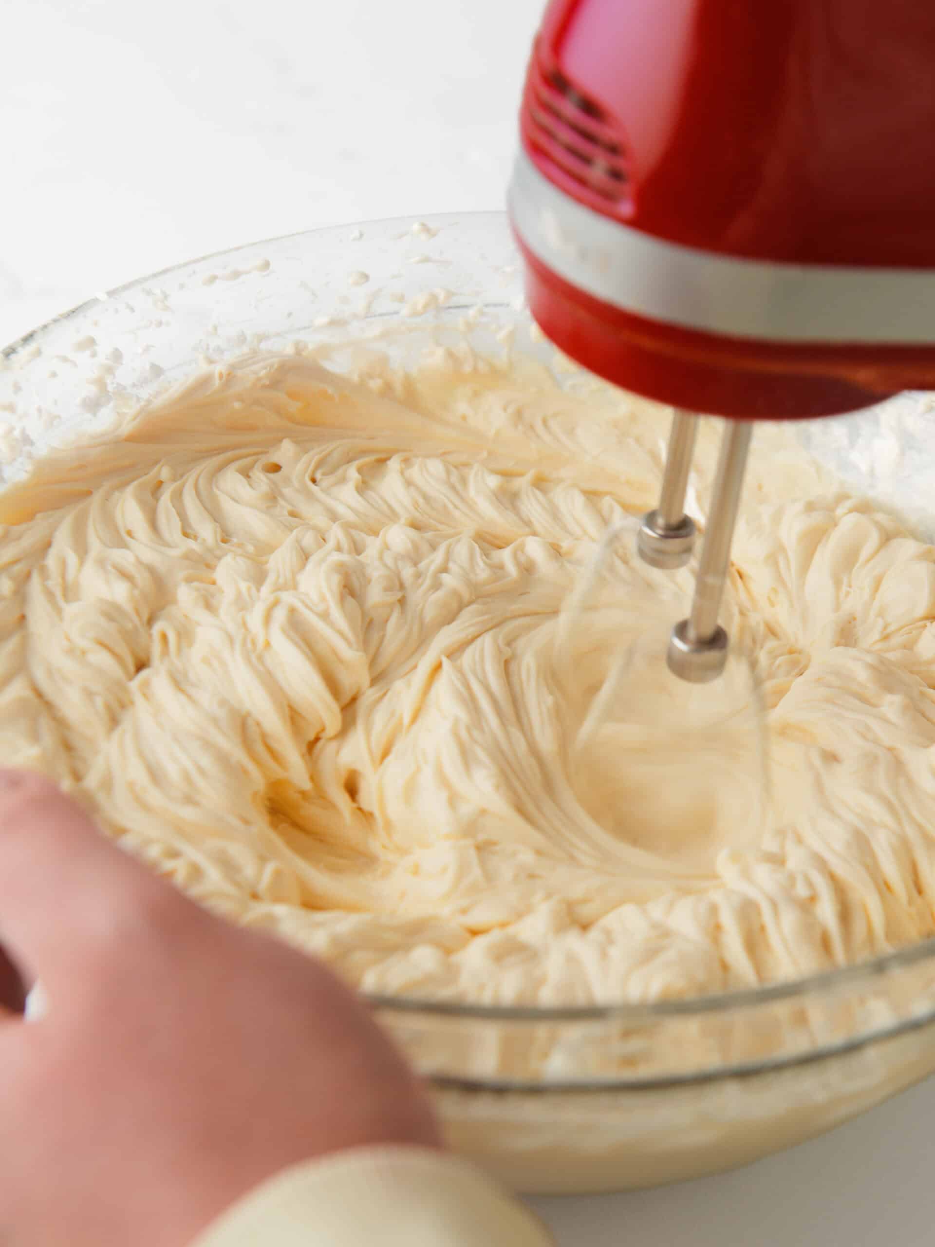 Creamy cheesecake filling in mixing bowl.