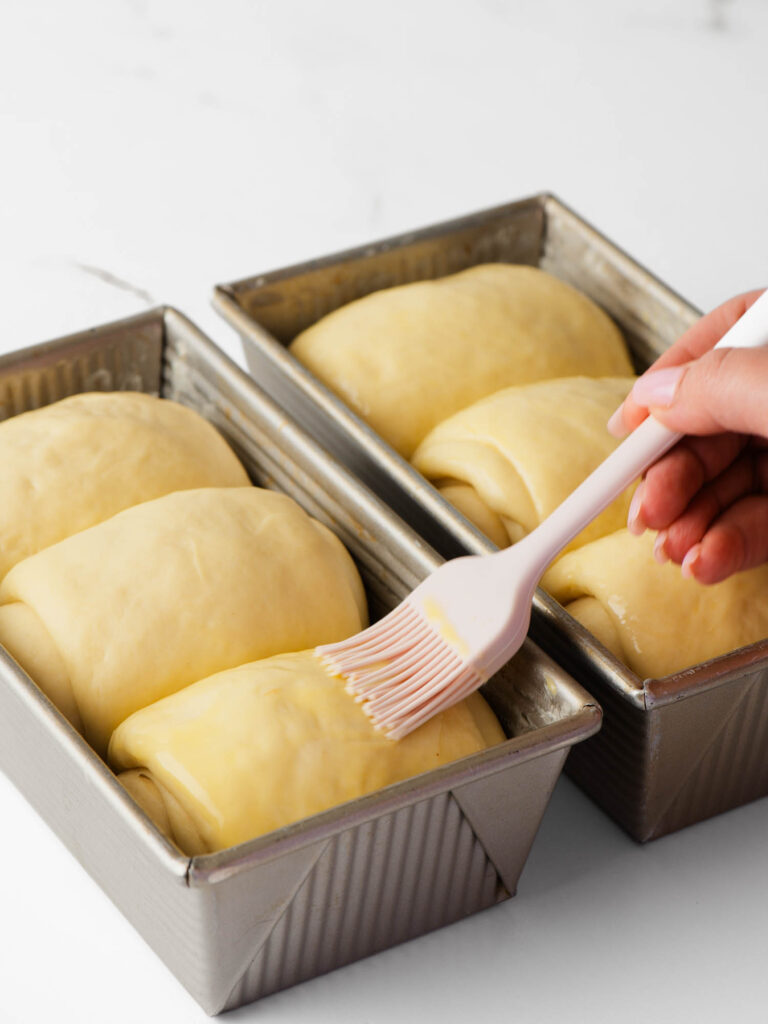 Brushing the soft dough with egg wash.