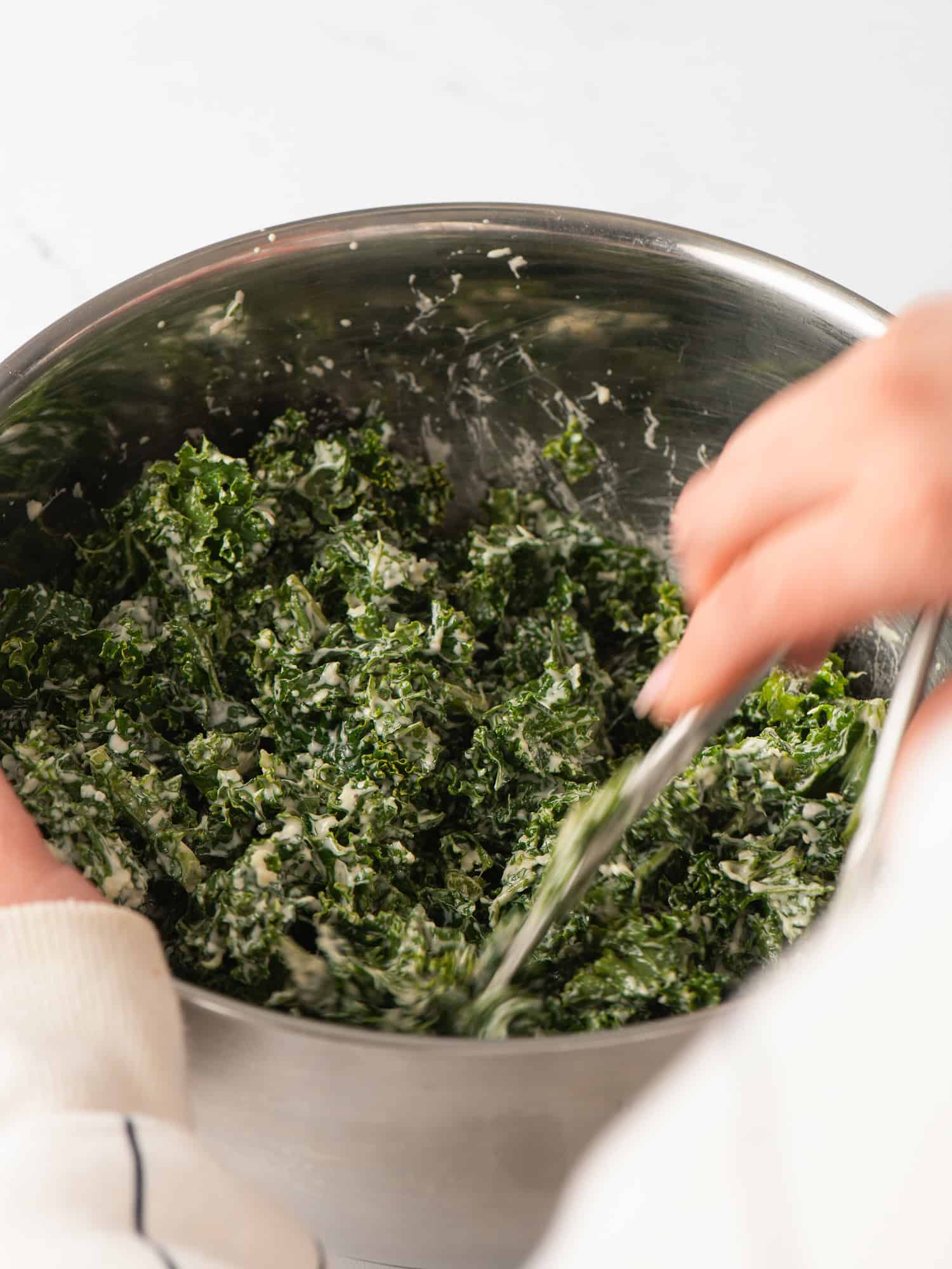 Tossing salad with the dressing.