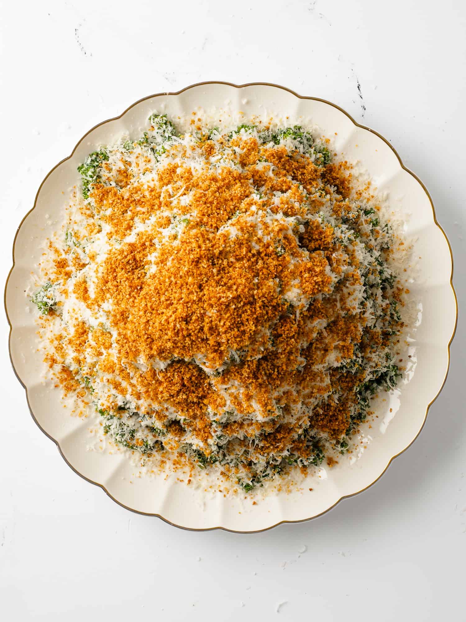 Kale Caesar Salad in serving plate with breadcrumbs and parmesan.