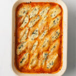 Stuffed Shells in a baking dish with melted cheese.