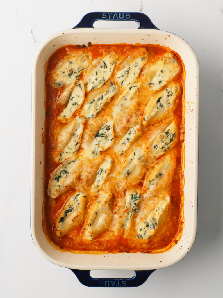 Stuffed Shells in a baking dish with melted cheese.