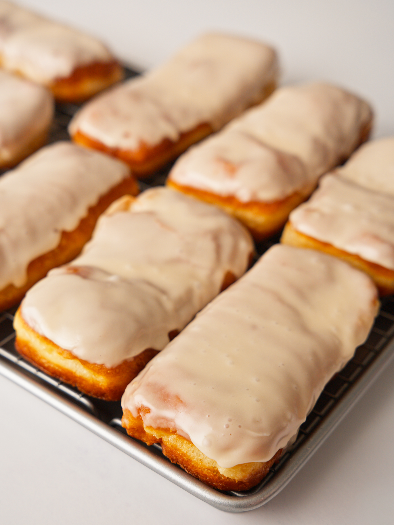 Maple bar donuts on rack with frosting.