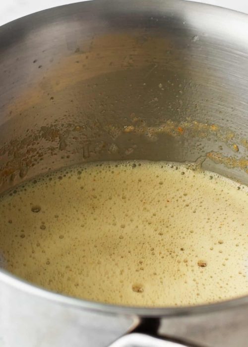 Melted butter in a stainless steel pot.